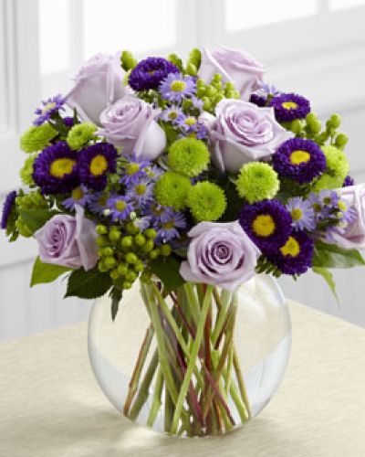 The Splendid Day Bouquet, set with roses and asters, creates the perfect bouquet for any of life's special moments.

Lavender roses, lavender monte casino asters, purple matsumoto asters, green hypericum berries, green button poms and lush greens create a stunning flower bouquet perfectly arranged in a clear glass bubble bowl vase to create a wonderful thank you, happy birthday or congratulations gift.