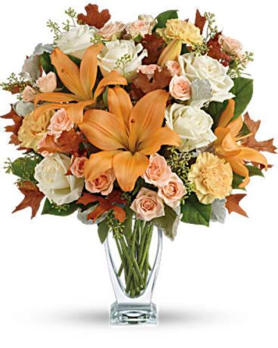 Capture the natural beauty of autumn with this stunning arrangement of lilies and roses in an elegant glass vase, sure to brighten any fall day.
This beautiful arrangement features white and peach roses, peach asiatic lilies and peach carnations and is finished with dusty miller, seeded eucalyptus, brown oak leaves and lemon leaf.